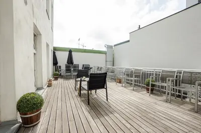Ein Balkon oder eine Terrasse in der Unterkunft Spacious apartment with huge shared terrace and grill located between city centre and Donau river