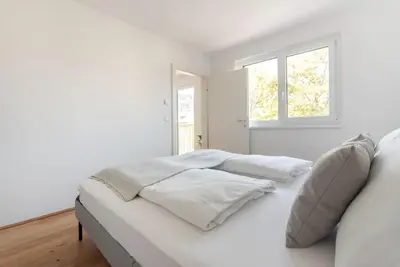 Ein Bett oder Betten in einem Zimmer der Unterkunft Grüne und zentrale Ruhelage im Neubau mit Balkon